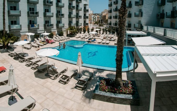 Het buitenzwembad en ligbedden van Pebbles Resort St. Paul's Bay